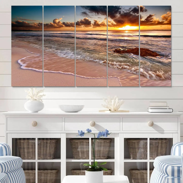 The Sunset Beach Waves Triptych Wall Art, featuring a tropical ocean scene on giclee canvas with a gallery wrap, adorns the wall in a cozy, coastal-themed living room.