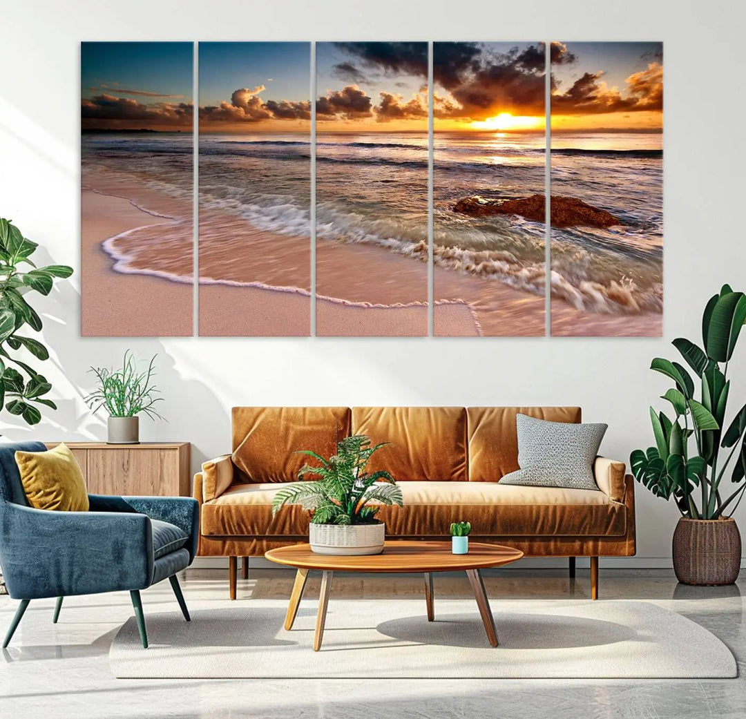 The Sunset Beach Waves Triptych Wall Art, featuring a tropical ocean scene on giclee canvas with a gallery wrap, adorns the wall in a cozy, coastal-themed living room.