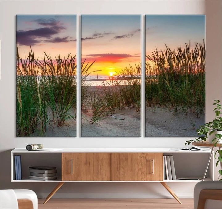 A set of three "Sunset Coastal Beach Wall Art Canvas Prints," featuring a beach sunset with tall grasses, gallery wrapped on museum-quality canvases.