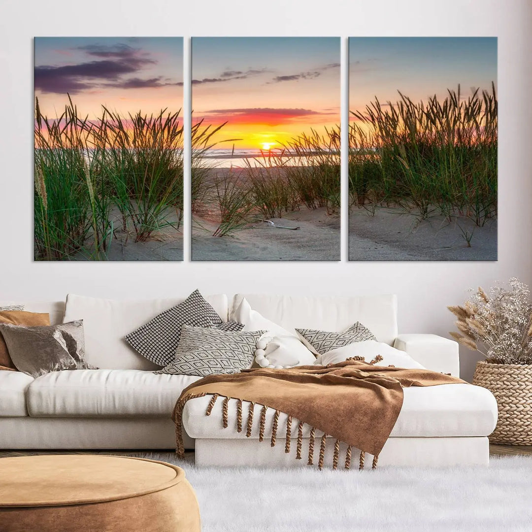 A set of three "Sunset Coastal Beach Wall Art Canvas Prints," featuring a beach sunset with tall grasses, gallery wrapped on museum-quality canvases.