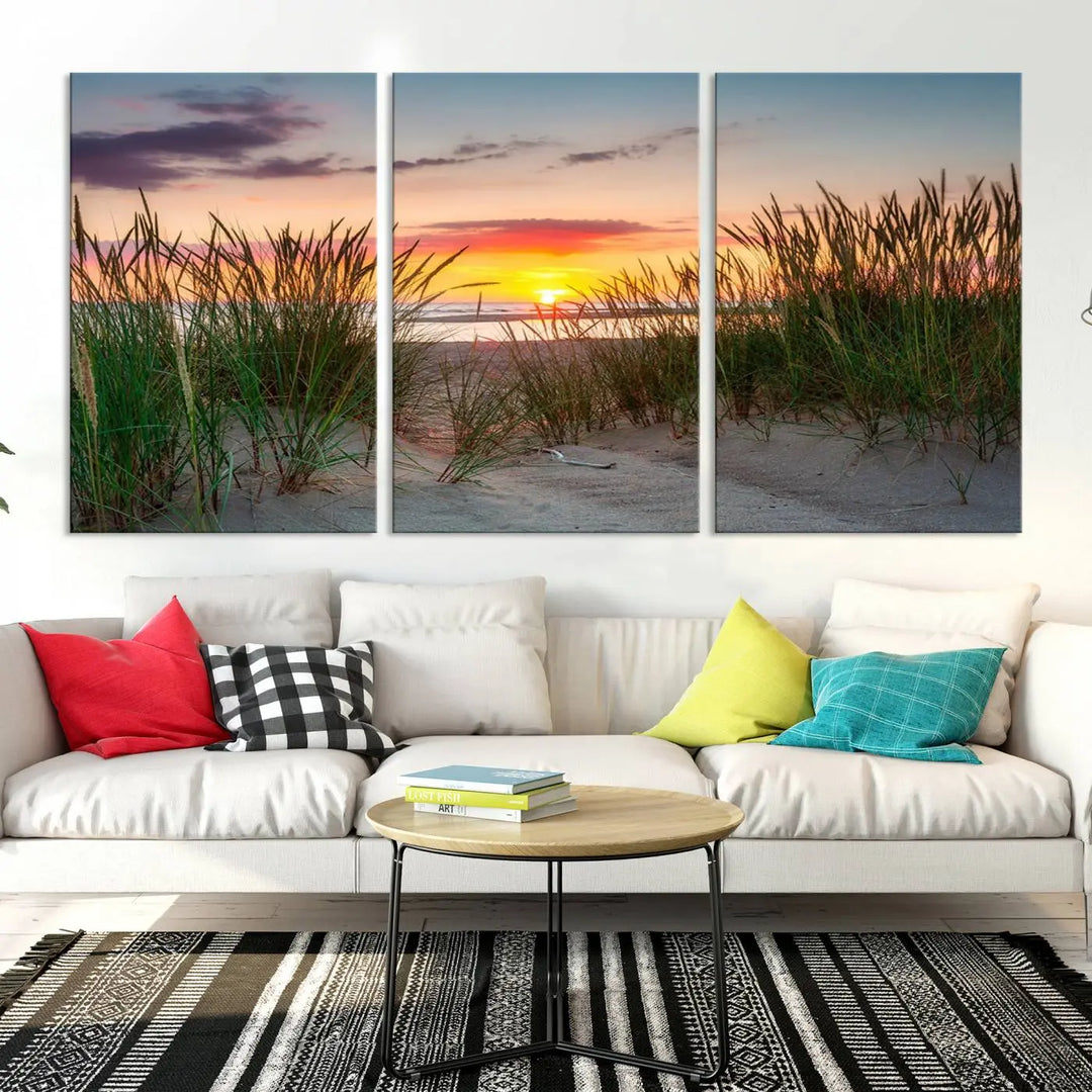 A set of three "Sunset Coastal Beach Wall Art Canvas Prints," featuring a beach sunset with tall grasses, gallery wrapped on museum-quality canvases.