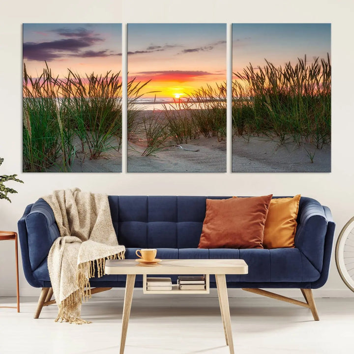 A set of three "Sunset Coastal Beach Wall Art Canvas Prints," featuring a beach sunset with tall grasses, gallery wrapped on museum-quality canvases.