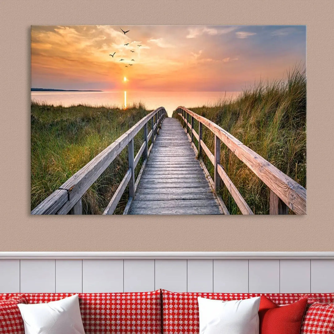 The Sunset Lakeside Pier Wall Art Canvas Print depicts a boardwalk leading towards a sunset over the ocean, framed by grassy dunes. Each piece is meticulously hand-assembled using museum-quality canvas to guarantee durability and vibrant colors.