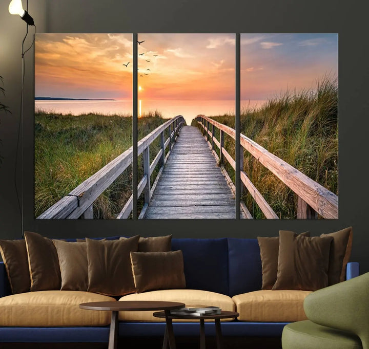 The Sunset Lakeside Pier Wall Art Canvas Print depicts a boardwalk leading towards a sunset over the ocean, framed by grassy dunes. Each piece is meticulously hand-assembled using museum-quality canvas to guarantee durability and vibrant colors.