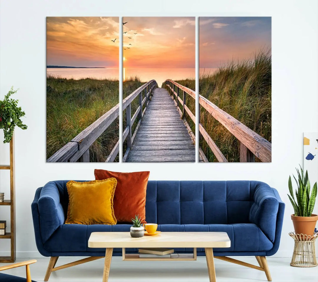 The Sunset Lakeside Pier Wall Art Canvas Print depicts a boardwalk leading towards a sunset over the ocean, framed by grassy dunes. Each piece is meticulously hand-assembled using museum-quality canvas to guarantee durability and vibrant colors.