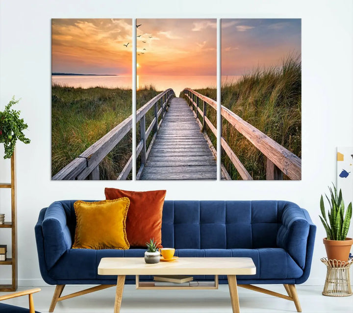 The Sunset Lakeside Pier Wall Art Canvas Print depicts a boardwalk leading towards a sunset over the ocean, framed by grassy dunes. Each piece is meticulously hand-assembled using museum-quality canvas to guarantee durability and vibrant colors.