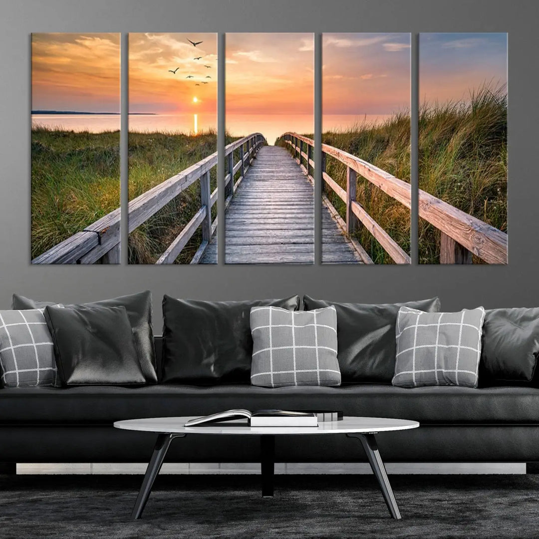 The Sunset Lakeside Pier Wall Art Canvas Print depicts a boardwalk leading towards a sunset over the ocean, framed by grassy dunes. Each piece is meticulously hand-assembled using museum-quality canvas to guarantee durability and vibrant colors.