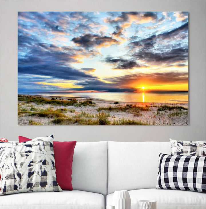 The living room features the Sunset On The Ocean Wall Art Canvas Print, a stunning large triptych depicting a sunset over a beach. This artwork is elegantly displayed on museum-quality canvas with UV-protective coating, ensuring both beauty and durability.