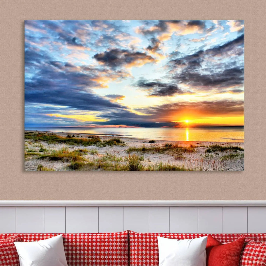 The living room features the Sunset On The Ocean Wall Art Canvas Print, a stunning large triptych depicting a sunset over a beach. This artwork is elegantly displayed on museum-quality canvas with UV-protective coating, ensuring both beauty and durability.