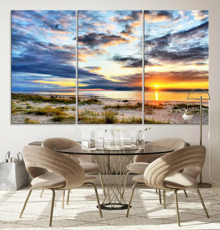 The living room features the Sunset On The Ocean Wall Art Canvas Print, a stunning large triptych depicting a sunset over a beach. This artwork is elegantly displayed on museum-quality canvas with UV-protective coating, ensuring both beauty and durability.