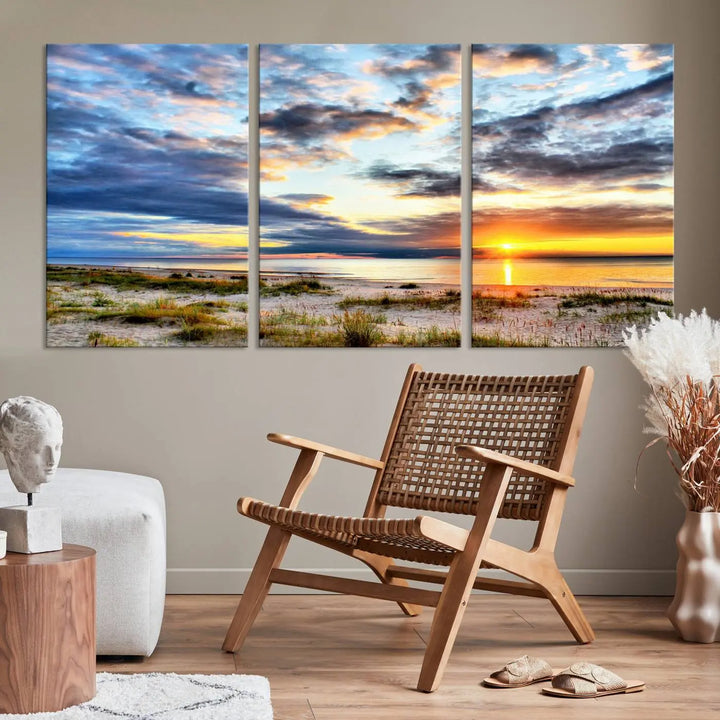 The living room features the Sunset On The Ocean Wall Art Canvas Print, a stunning large triptych depicting a sunset over a beach. This artwork is elegantly displayed on museum-quality canvas with UV-protective coating, ensuring both beauty and durability.