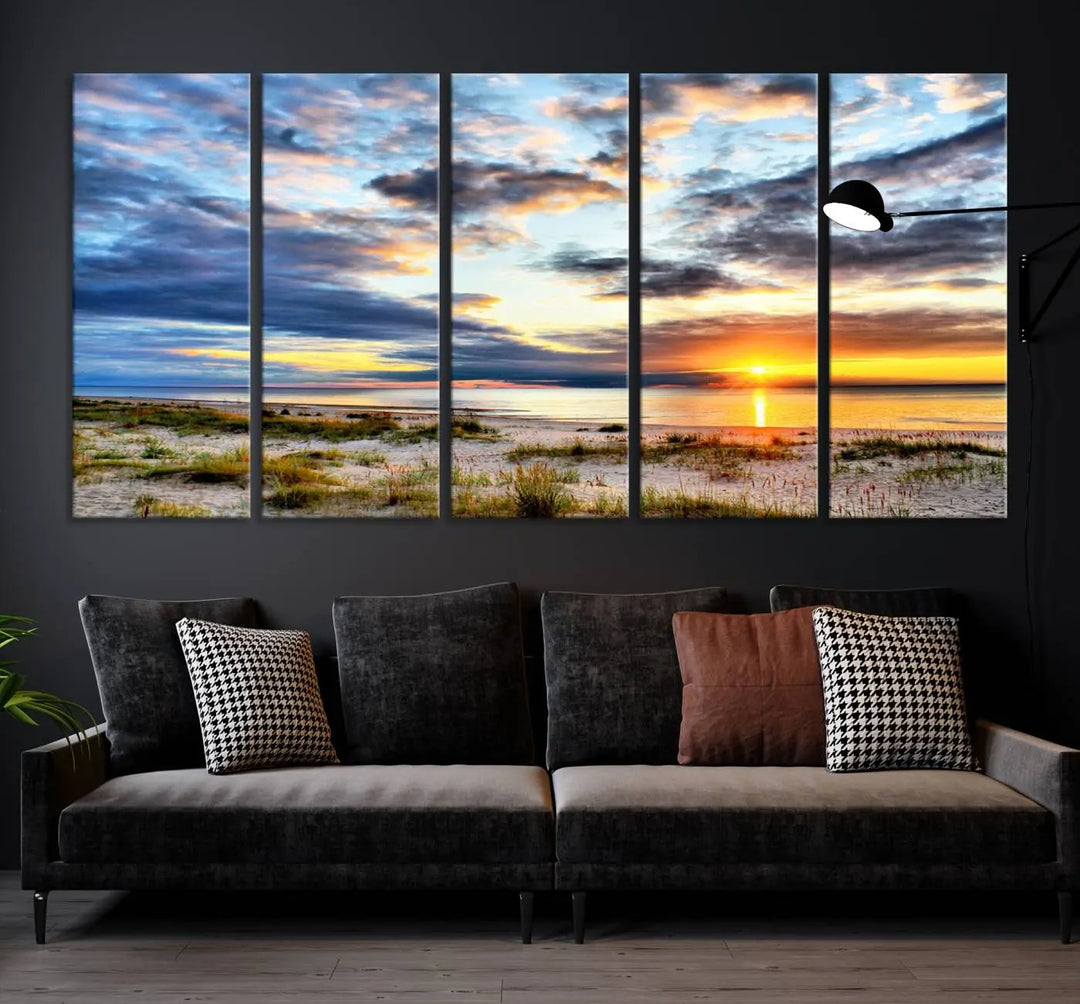 The living room features the Sunset On The Ocean Wall Art Canvas Print, a stunning large triptych depicting a sunset over a beach. This artwork is elegantly displayed on museum-quality canvas with UV-protective coating, ensuring both beauty and durability.