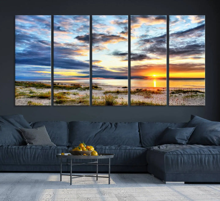 The living room features the Sunset On The Ocean Wall Art Canvas Print, a stunning large triptych depicting a sunset over a beach. This artwork is elegantly displayed on museum-quality canvas with UV-protective coating, ensuring both beauty and durability.