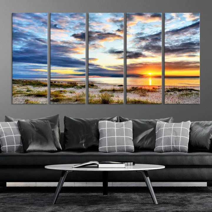 The living room features the Sunset On The Ocean Wall Art Canvas Print, a stunning large triptych depicting a sunset over a beach. This artwork is elegantly displayed on museum-quality canvas with UV-protective coating, ensuring both beauty and durability.