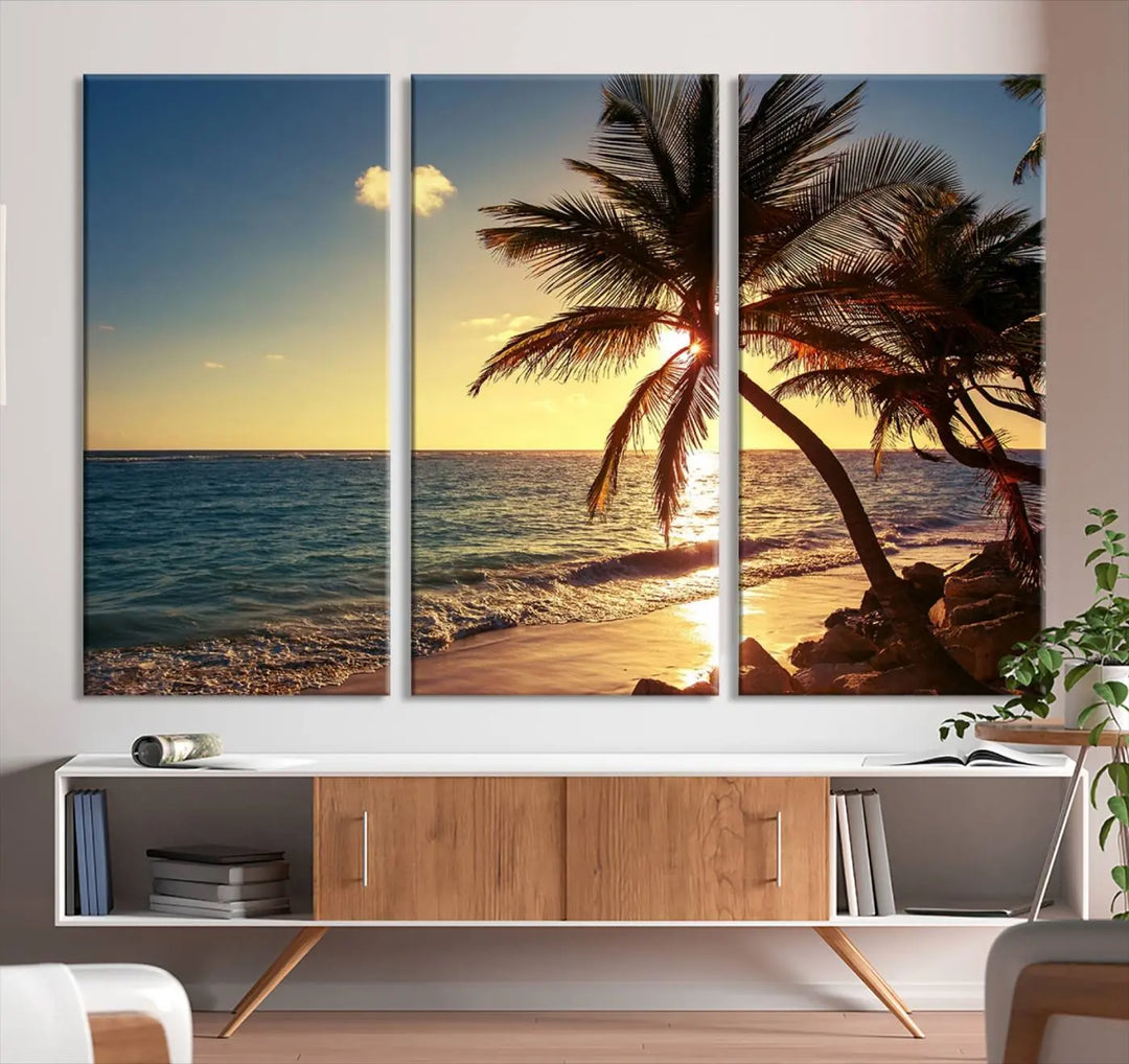 The Sunset Palm Trees Wall Art Canvas Print, a triptych masterpiece depicting a tropical beach sunset with palm trees, is expertly displayed on museum-quality canvases.