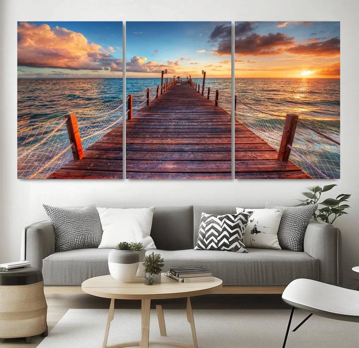 The Sunset Pier Canvas Wall Art is a triptych featuring an ocean landscape that elegantly captures a tranquil beach sunset with gentle ocean waves. It comes beautifully framed and ready to hang.