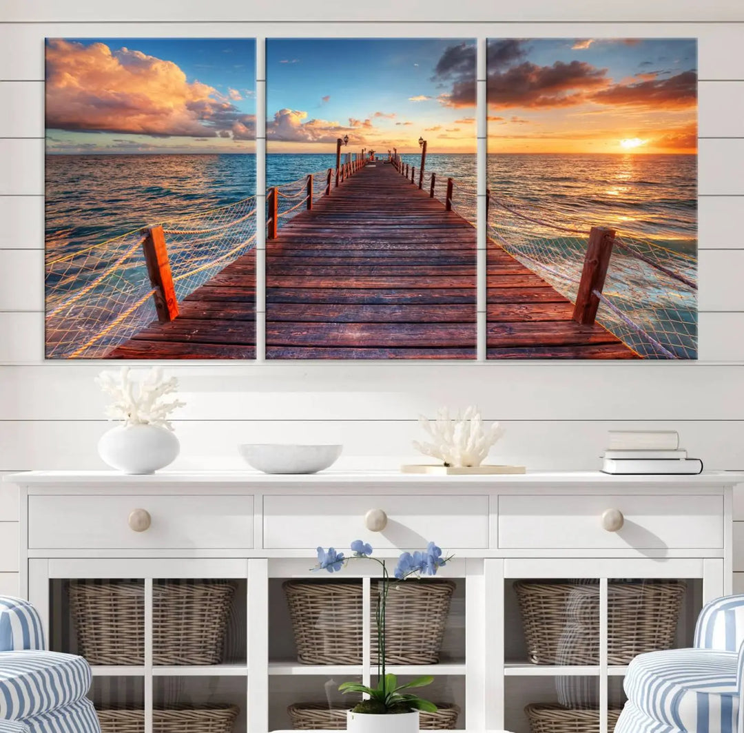 The Sunset Pier Canvas Wall Art is a triptych featuring an ocean landscape that elegantly captures a tranquil beach sunset with gentle ocean waves. It comes beautifully framed and ready to hang.