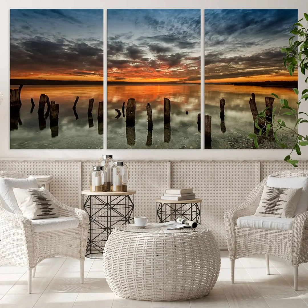 The "Sunset Reflection on Wooden Pier Giclee Canvas Print" is a panoramic wall art piece showcasing serene nature photography with a colorful sunset over water and wooden posts.