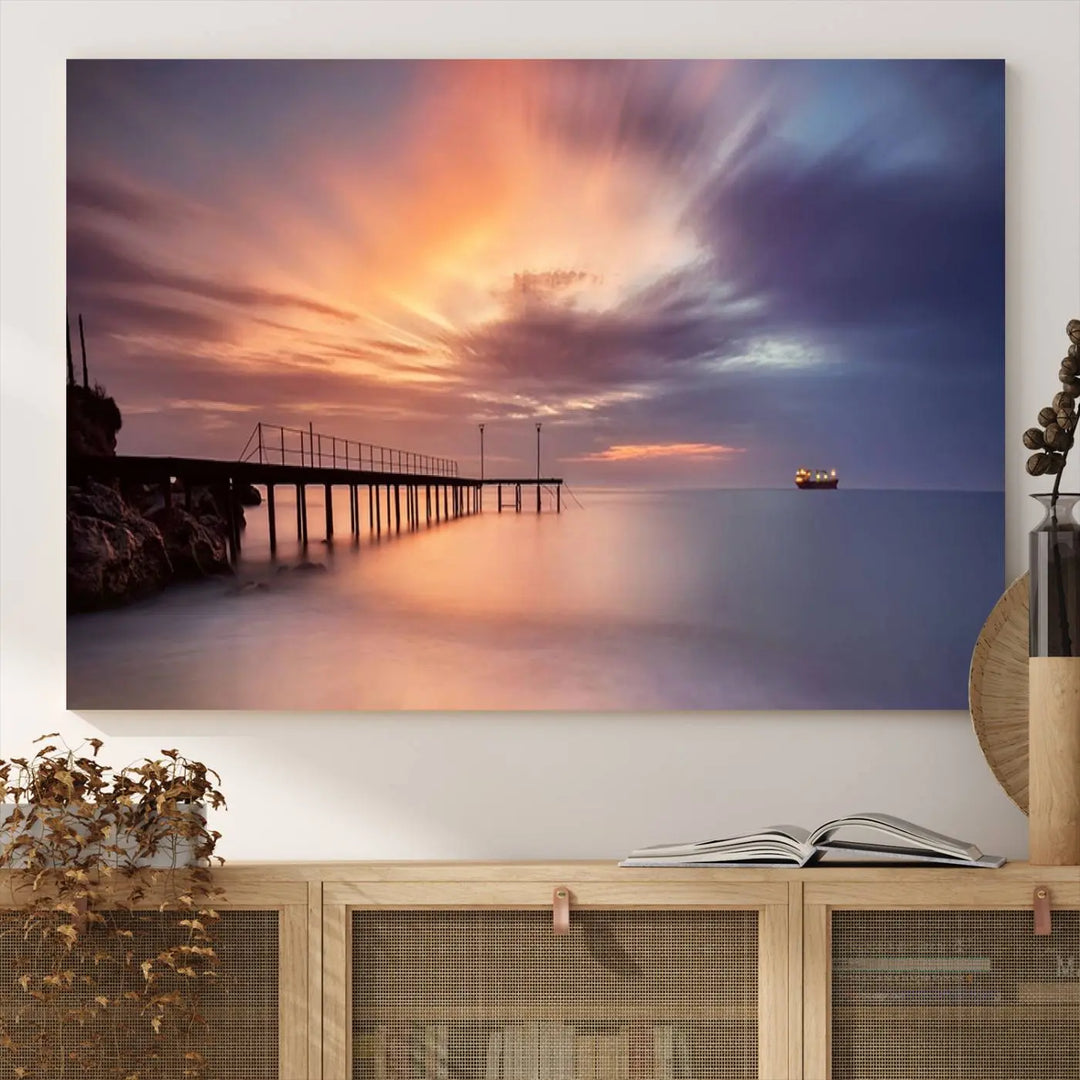 The Sunset Serenity Pier Canvas Art, a giclee canvas print with gallery wrap, beautifully captures a triptych of tranquility as the sun sets over calm waters. Featuring a pier on the left and a ship on the horizon, it adds an elegant touch to any living space with its serene coastal decor.