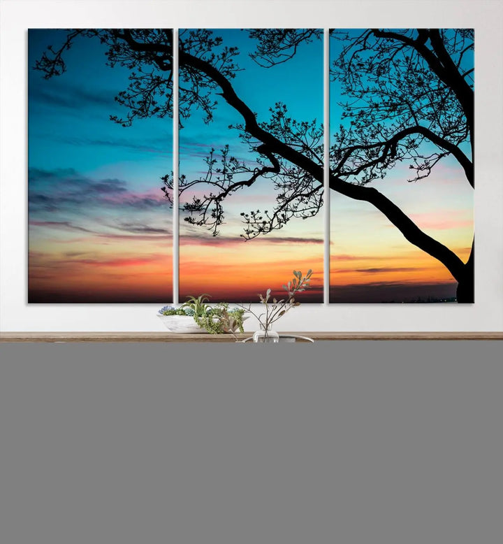 The "Sunset Tree Leaves Wall Art Canvas Print" features a triptych of tree branches against a vibrant sunset sky. Each piece is printed on museum-quality canvas and finished with a UV-protective coating, ensuring it is both stunning and ready to hang.