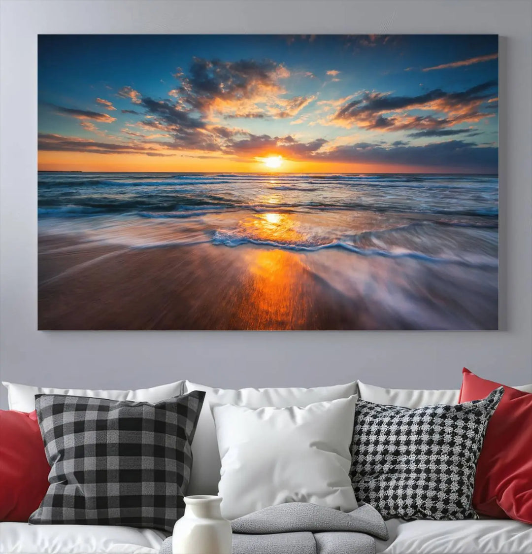 The Sunset on Beach Canvas Wall Art Canvas Print is a triptych depicting a sunset over the ocean. Each piece of this museum-quality polycotton canvas is gallery wrapped and has a UV-protective coating to maintain its vibrant colors. It is displayed on a living room wall.