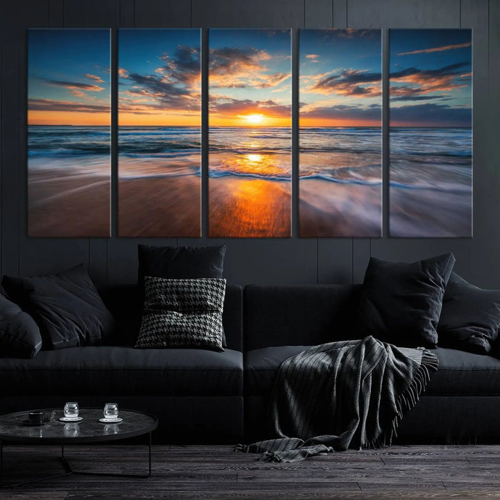 The Sunset on Beach Canvas Wall Art Canvas Print is a triptych depicting a sunset over the ocean. Each piece of this museum-quality polycotton canvas is gallery wrapped and has a UV-protective coating to maintain its vibrant colors. It is displayed on a living room wall.