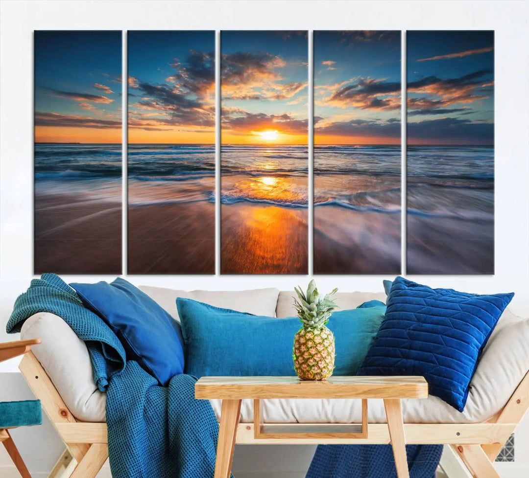 The Sunset on Beach Canvas Wall Art Canvas Print is a triptych depicting a sunset over the ocean. Each piece of this museum-quality polycotton canvas is gallery wrapped and has a UV-protective coating to maintain its vibrant colors. It is displayed on a living room wall.