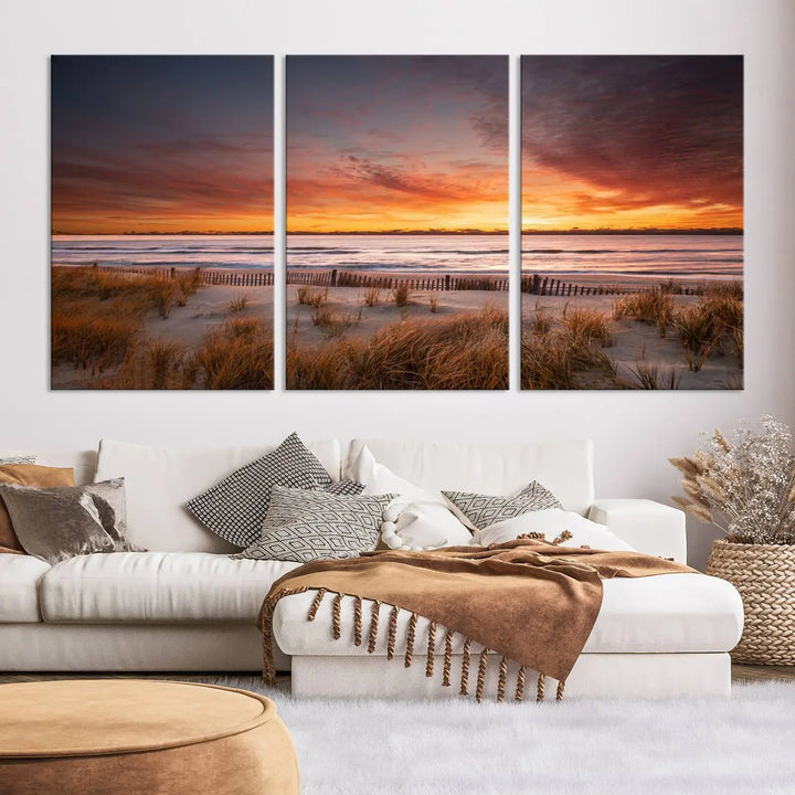 Sunset on The Beach Wall Art Canvas Print features a triptych of a beach at sunset with vivid orange skies, presented on museum-quality canvas. Each section is gallery wrapped, offering lasting beauty with its UV-protective coating.