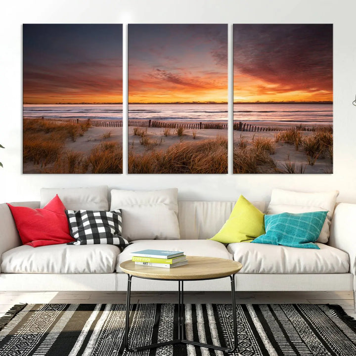 Sunset on The Beach Wall Art Canvas Print features a triptych of a beach at sunset with vivid orange skies, presented on museum-quality canvas. Each section is gallery wrapped, offering lasting beauty with its UV-protective coating.