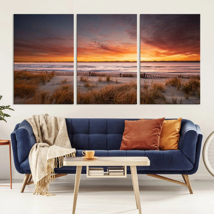 Sunset on The Beach Wall Art Canvas Print features a triptych of a beach at sunset with vivid orange skies, presented on museum-quality canvas. Each section is gallery wrapped, offering lasting beauty with its UV-protective coating.