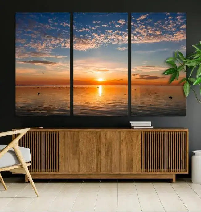 The "Sunset on the Sea Wall Art Canvas Print" graces the space as a stunning triptych, with its museum-quality canvas showcasing a serene sunset over water. The gallery-wrapped edges enhance depth and elegance, creating an ideal centerpiece for any room.