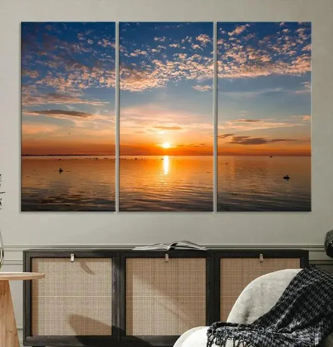 The "Sunset on the Sea Wall Art Canvas Print" graces the space as a stunning triptych, with its museum-quality canvas showcasing a serene sunset over water. The gallery-wrapped edges enhance depth and elegance, creating an ideal centerpiece for any room.