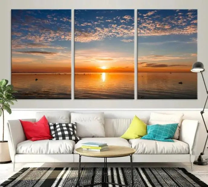 The "Sunset on the Sea Wall Art Canvas Print" graces the space as a stunning triptych, with its museum-quality canvas showcasing a serene sunset over water. The gallery-wrapped edges enhance depth and elegance, creating an ideal centerpiece for any room.