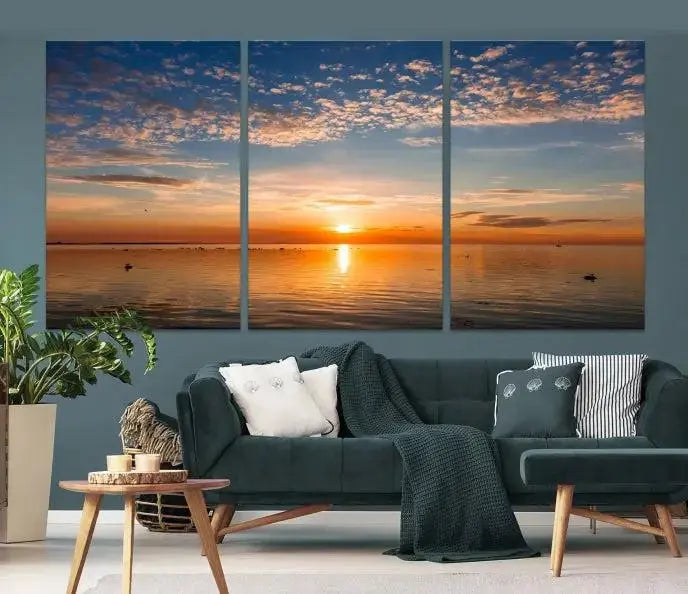 The "Sunset on the Sea Wall Art Canvas Print" graces the space as a stunning triptych, with its museum-quality canvas showcasing a serene sunset over water. The gallery-wrapped edges enhance depth and elegance, creating an ideal centerpiece for any room.