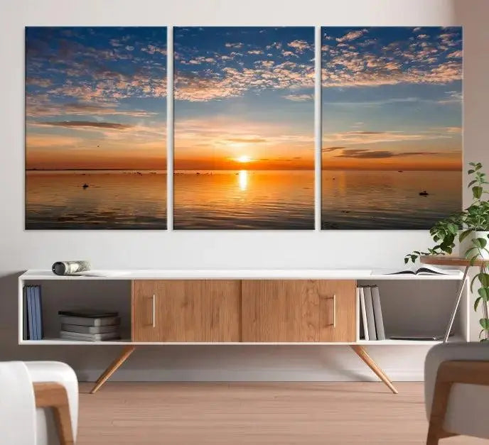 The "Sunset on the Sea Wall Art Canvas Print" graces the space as a stunning triptych, with its museum-quality canvas showcasing a serene sunset over water. The gallery-wrapped edges enhance depth and elegance, creating an ideal centerpiece for any room.