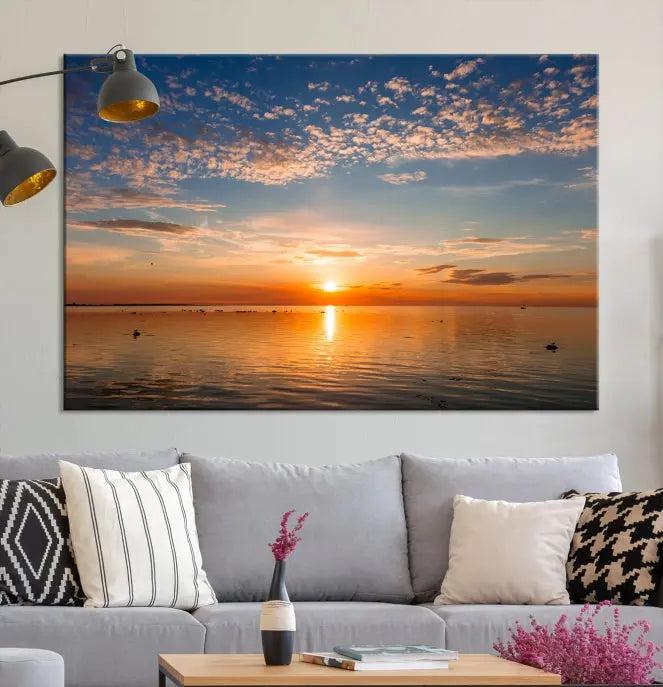 The "Sunset on the Sea Wall Art Canvas Print" graces the space as a stunning triptych, with its museum-quality canvas showcasing a serene sunset over water. The gallery-wrapped edges enhance depth and elegance, creating an ideal centerpiece for any room.