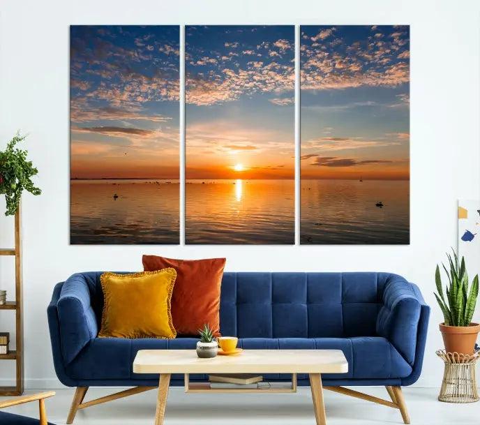 The "Sunset on the Sea Wall Art Canvas Print" graces the space as a stunning triptych, with its museum-quality canvas showcasing a serene sunset over water. The gallery-wrapped edges enhance depth and elegance, creating an ideal centerpiece for any room.