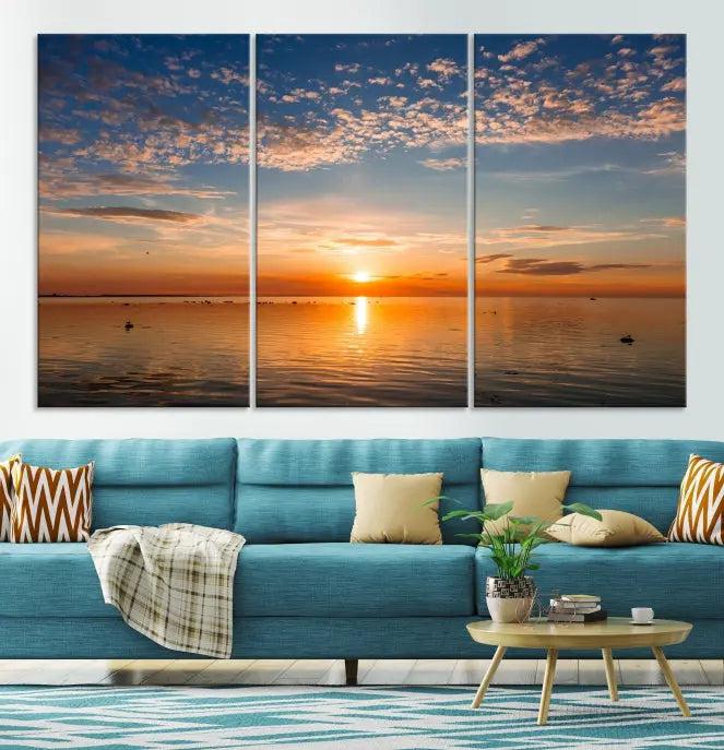 The "Sunset on the Sea Wall Art Canvas Print" graces the space as a stunning triptych, with its museum-quality canvas showcasing a serene sunset over water. The gallery-wrapped edges enhance depth and elegance, creating an ideal centerpiece for any room.