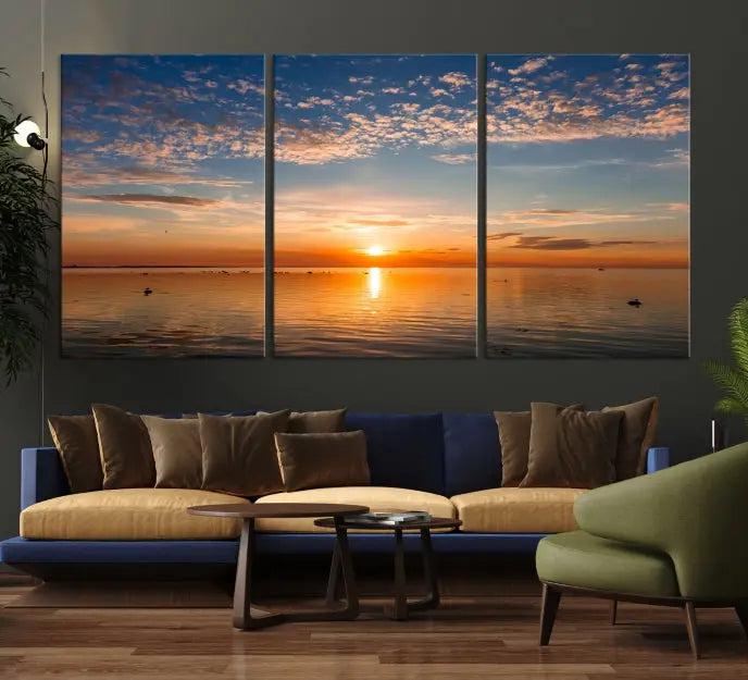 The "Sunset on the Sea Wall Art Canvas Print" graces the space as a stunning triptych, with its museum-quality canvas showcasing a serene sunset over water. The gallery-wrapped edges enhance depth and elegance, creating an ideal centerpiece for any room.