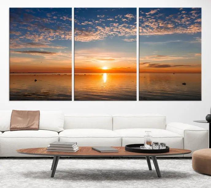 The "Sunset on the Sea Wall Art Canvas Print" graces the space as a stunning triptych, with its museum-quality canvas showcasing a serene sunset over water. The gallery-wrapped edges enhance depth and elegance, creating an ideal centerpiece for any room.