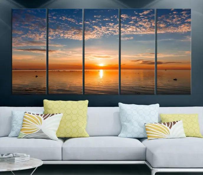 The "Sunset on the Sea Wall Art Canvas Print" graces the space as a stunning triptych, with its museum-quality canvas showcasing a serene sunset over water. The gallery-wrapped edges enhance depth and elegance, creating an ideal centerpiece for any room.