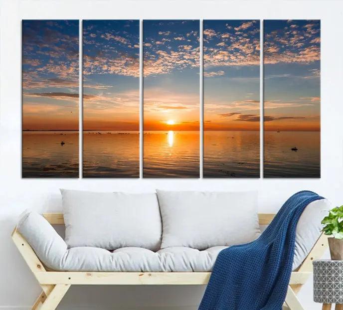 The "Sunset on the Sea Wall Art Canvas Print" graces the space as a stunning triptych, with its museum-quality canvas showcasing a serene sunset over water. The gallery-wrapped edges enhance depth and elegance, creating an ideal centerpiece for any room.