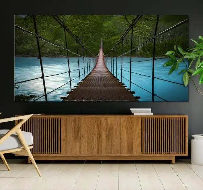 A breathtaking 3-panel nature photography piece titled "Suspension Bridge Over River Canvas Art" beautifully enhances the living room wall, adding an exquisite touch of scenic wall art.