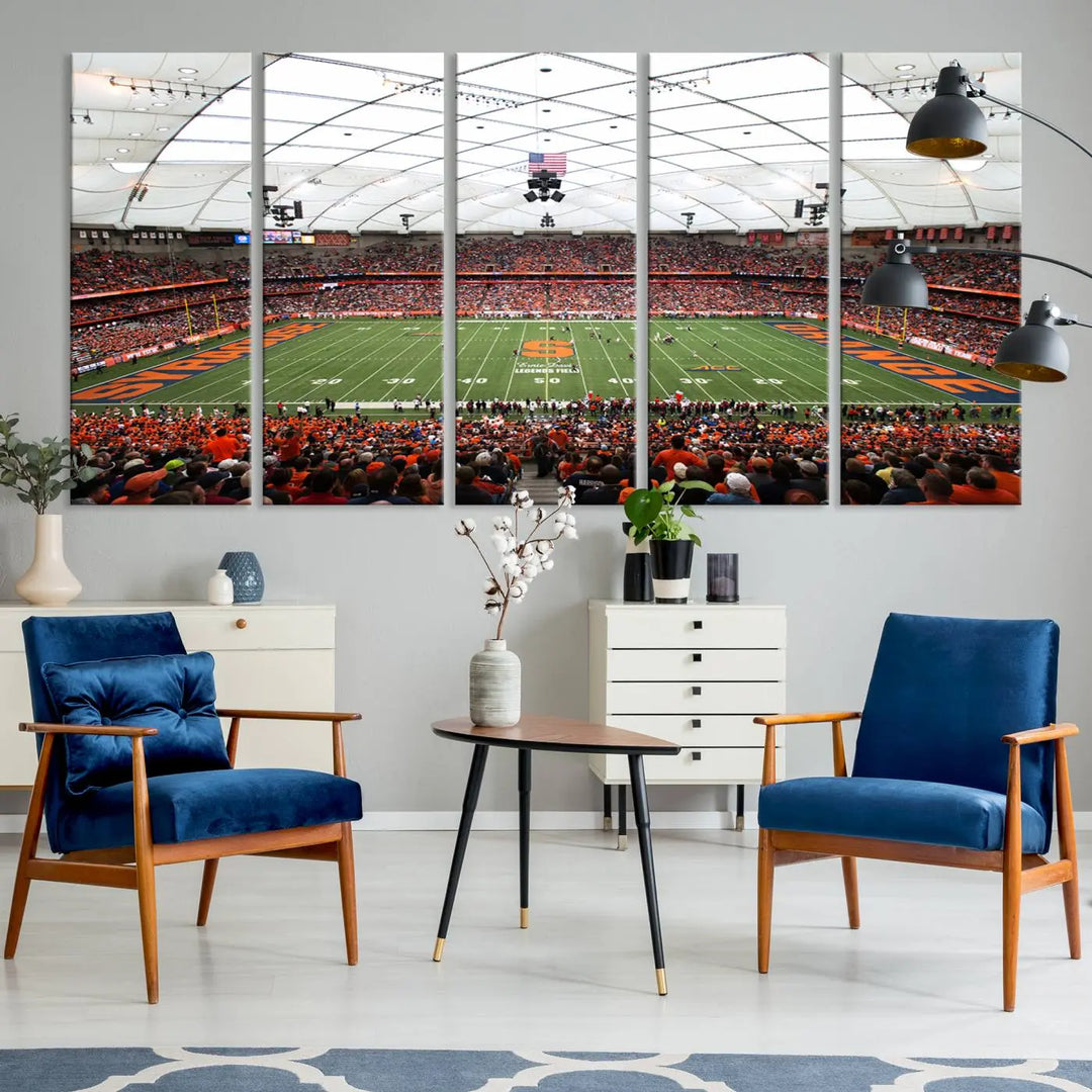 The living room boasts a sizable, three-panel canvas artwork on the wall, depicting the vibrant crowd of the Syracuse University Orange football team at Syracuse JMA Wireless Dome, complete with a gallery-quality finish.