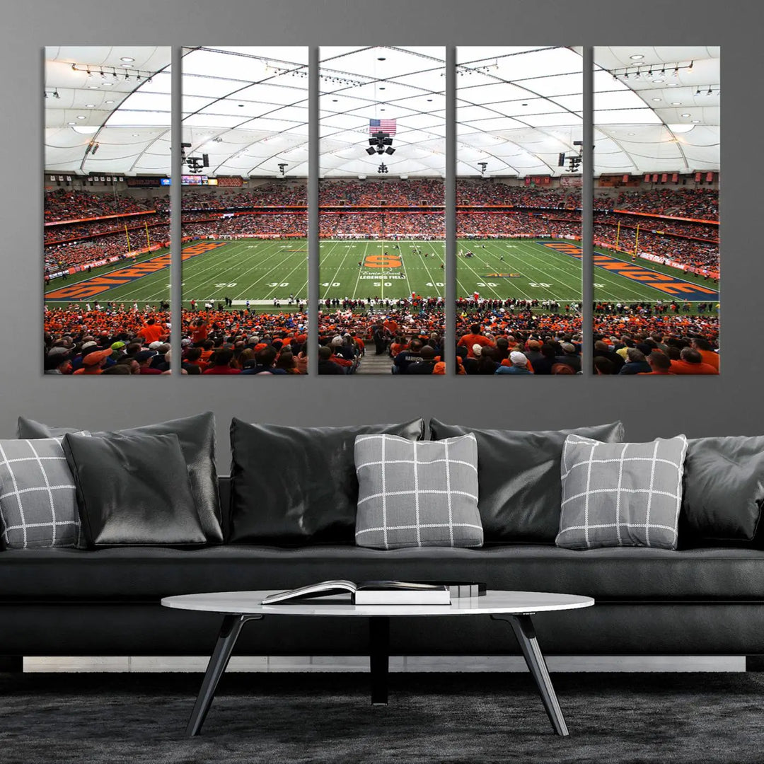 The living room boasts a sizable, three-panel canvas artwork on the wall, depicting the vibrant crowd of the Syracuse University Orange football team at Syracuse JMA Wireless Dome, complete with a gallery-quality finish.