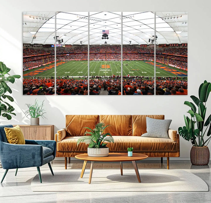 The living room boasts a sizable, three-panel canvas artwork on the wall, depicting the vibrant crowd of the Syracuse University Orange football team at Syracuse JMA Wireless Dome, complete with a gallery-quality finish.