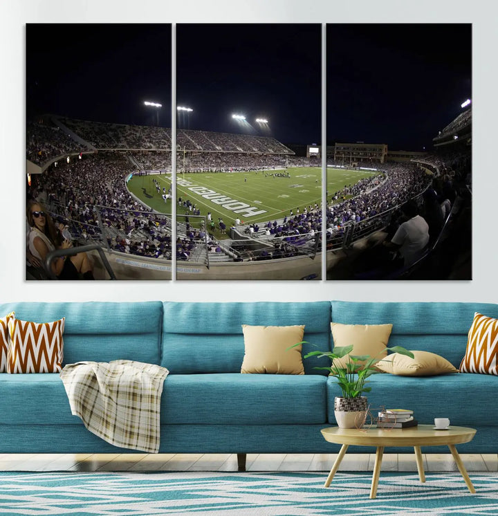 Immerse yourself in the vibrant energy of a packed football stadium at night with bright lights illuminating the field and stands, beautifully captured in the TCU Horned Frogs Football Team Print on premium canvas. This wall art features Fort Worth's Amon G. Carter Stadium.