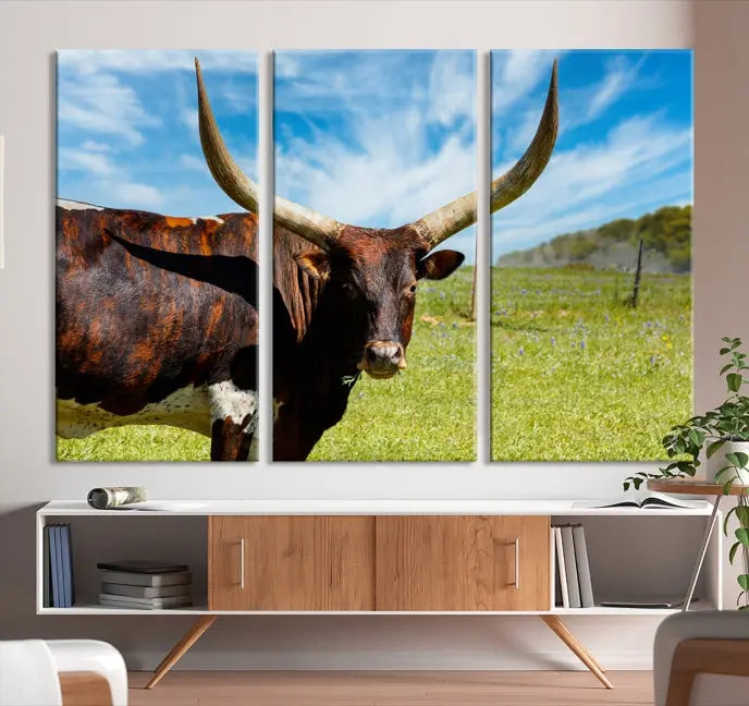 The Texas Longhorn Cow Wall Art Animal Canvas Print is a three-panel portrayal of a longhorn cow in a grassy field on museum-quality canvas with UV-protective coating.