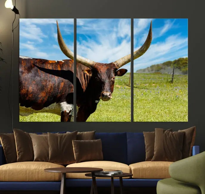 The Texas Longhorn Cow Wall Art Animal Canvas Print is a three-panel portrayal of a longhorn cow in a grassy field on museum-quality canvas with UV-protective coating.