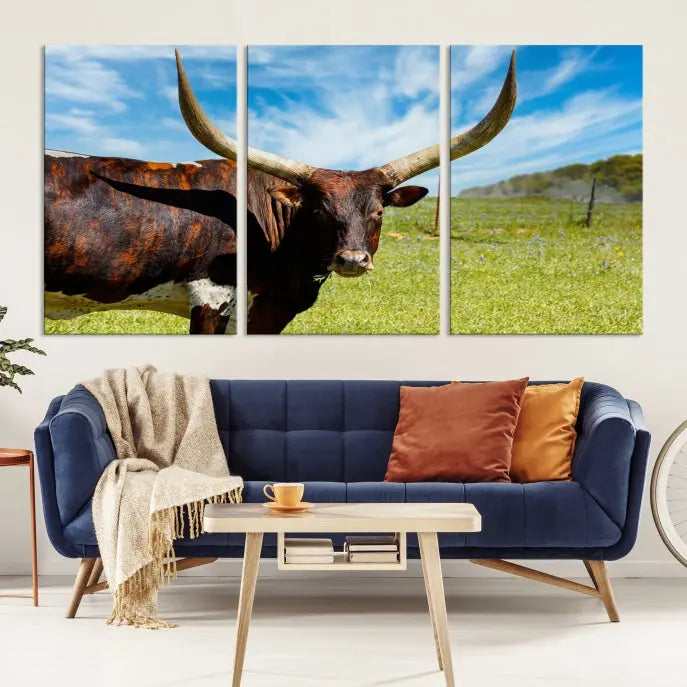 The Texas Longhorn Cow Wall Art Animal Canvas Print is a three-panel portrayal of a longhorn cow in a grassy field on museum-quality canvas with UV-protective coating.